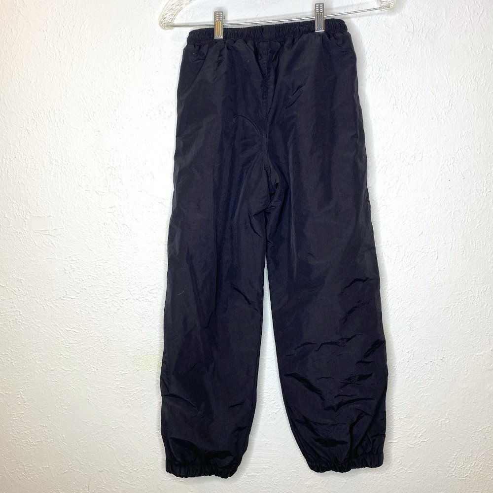 REI kid's size Medium 8/10, elastic waist, fleece lined snow/ski pants in black.